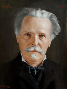 Portrait des Schriftstellers vor dunklem Hintergund. Er trägt graues volles Haar und einen Schnurrbart
