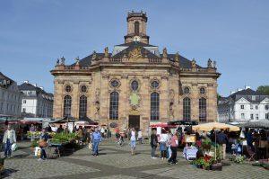 Blick auf die Kirchenfront mit dem Wochenmarkt vor der Kirche