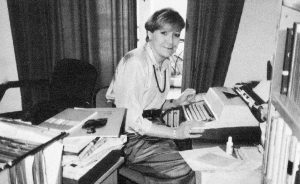 Foto wie die Autorin an der Schreibmaschine an ihrem Arbeitsplatz sitzt